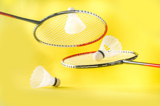 Summer sport activity concept. Two badminton paddle rackets with shuttlecocks on trend bright yellow background