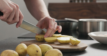Man cutting potatoes before baking