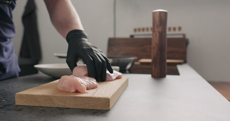 man hands put chicken fillet on oak board