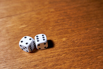 Two white dice on a wooden table