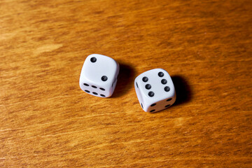 Two white dice on a wooden table