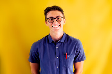 Young geek boy on yellow background.  Smiling face and geek look for back to school and website advertising. - obrazy, fototapety, plakaty