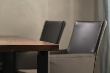 Minimalist kitchen interior with walnut dining table and leather arm chairs