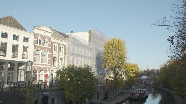 Beautiful old houses near Dutch canal with buildings under renovation