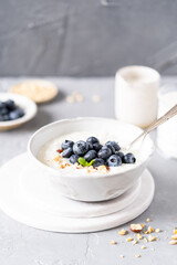 Rice porridge on coconut milk with blueberries and nuts on a gray background. Healthy breakfast, healthy food