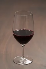 Fotobehang Red wine in wineglass on black walnut table © GCapture