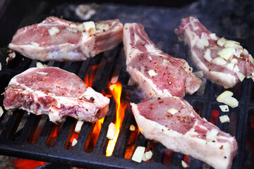  BBQ Grill Pit With Glowing And Flaming Hot, raw steaks and onion, food background, Close-Up. Selective focus.