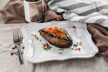 baked aubergine stuffed with tomatoes and vegetables in sauce on the table