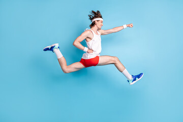 Full length profile photo of funny millennial brunet guy run wear singlet shorts sneakers socks isolated on blue background