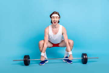 Fototapeta na wymiar Full length body size photo male athlete keeping barbell wearing sportswear isolated pastel blue color background