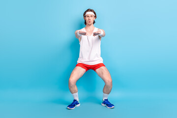 Fototapeta premium Full length body size photo man doing stretching wearing sportswear headband isolated pastel blue color background