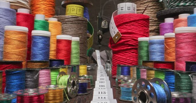 Old tailor's workshop with threads on spools and tape measure.