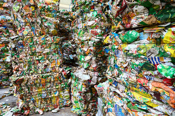 Fototapeta na wymiar Grodno, Belarus - October 2018: Pressed bales of used cardboard beverages and juice PET packages sorted for further processing at modern waste recycling plant. Concept of renewability raw materials.