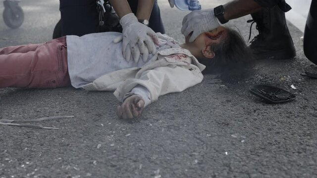 Paramedics doing cardiac massage for indian child on road
