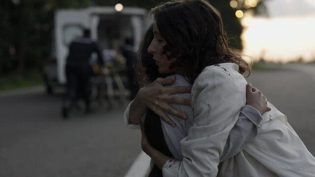 Mother embracing daughter while doctors helping father