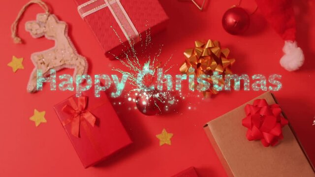 Animation of happy christmas text over presents, decorations on red background