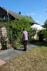 Fototapeta na wymiar FU 2020-07-28 Erftstadt 42 Jemand steht im Garten vor einem Strauch