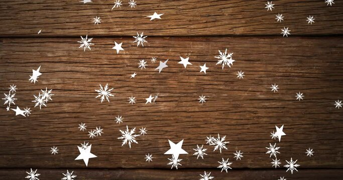 Animation of christmas stars falling over wooden background