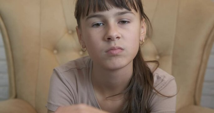 Stressed teen in armchair. A stresser young girl sitting in loneliness in the armchair.