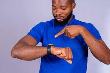 young black man eagerly pointing to his watch, suggesting that you hurry concept