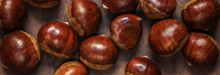 Chestnuts on on an old board with copy space. Autumn fall concept. Horse chestnuts top view.