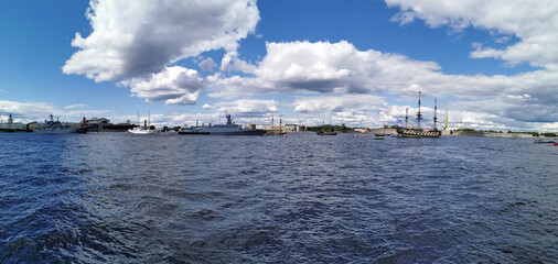 Naklejka premium Panoramic view of the warships, frigates and sailboats built in the Neva water area for the Day of the Navy in St. Petersburg.