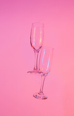 two glasses of champagne with neon pink lights. modern futurism 2022 year background. minimalism. surrealism. creative decoration idea
