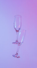 two glasses of champagne with neon purple lights. modern futurism 2022 year background. minimalism....