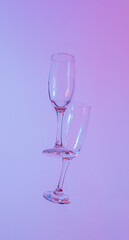 two glasses of champagne with neon purple lights. modern futurism 2022 year background. minimalism. surrealism. creative decoration idea