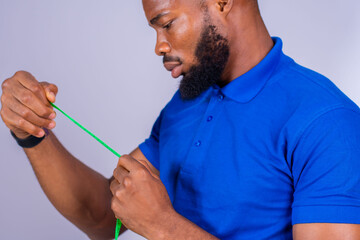 handsome young black man excitedly stretching a measuring tape to his side