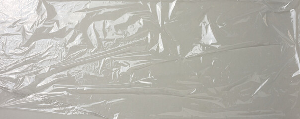 texture of crumpled transparent polyethylene on a gray background, full frame