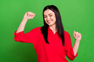 Photo of optimistic brunette manager lady hands fists wear red shirt isolated on green color background