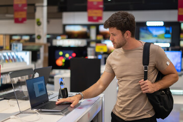 Male customer exploring new netbook in store