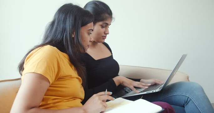 ouple of Indian ladies discussing something while sitting on a couch