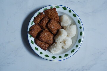 a plate of tempeh and glutinous rice balls