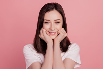Photo of young cheerful girl hands touch cheeks dream toothy smile oral care isolated over pink color background