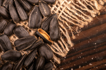 Fried black sunflower seeds scattered on the table, close-up, selective focus.