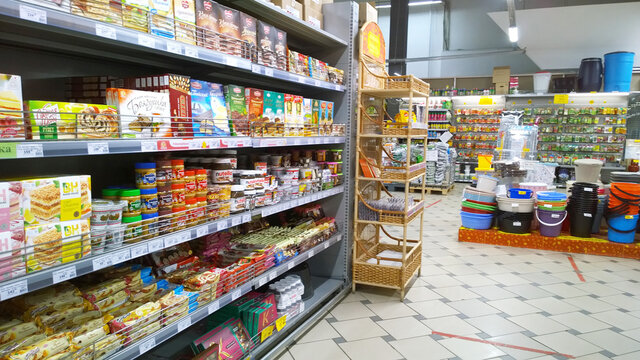 Rows of shelves with fresh products in major Russian supermarket. Consumer household goods, food. Retail industry. Aisle. Grocery store. Rack. Modern shop. St. Petersburg, Russia - November 14, 2021