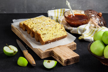 Apple and coconut loaf cake on wooden cutting board