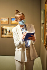 Woman visitor in the historical museum looking at pictures