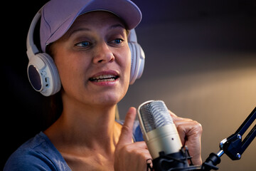 Beautiful Woman In A Cap And White Headphones Leads A Live Stream