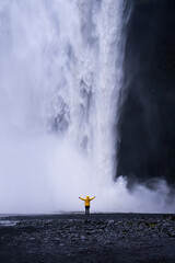 Mujer debajo del impresionante salto de agua de Skógafoss, de más de 60 metros. (Islandia)