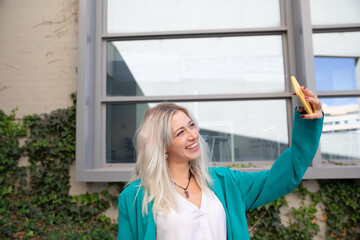 Fototapeta premium a professional young blonde woman using a smartphone. selfie