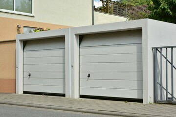 Moderne Beton-Garage mit Automatik-Tor in der Hauszufahrt