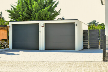 Moderne Beton-Garage mit Automatik-Tor in der Hauszufahrt