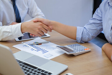 close up focus on businessman hand shake with businesswoman after completed deal of company profit...