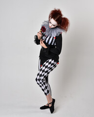   halloween, character, costume, figure pose, posing, portrait, gesture,  isolated,  magical, dynamic movement,  isolated,  studio background,  red hair, circus, theatre, jester, clown,  
full length,