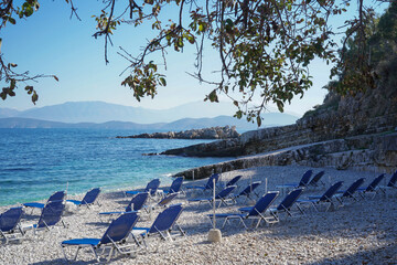 empty sunbeds on beauiful turquoise Bataria Beach in Kassiopi, Corfu island, Greece