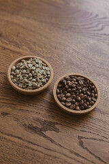 Green coffee beans next to roasted coffee beans on a stand on a wooden table. Unroasted coffee. Roasted coffee. Raw coffee.