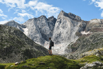 Fototapeta na wymiar Young backpacker watching the Vignemale north face in french Pyrenees